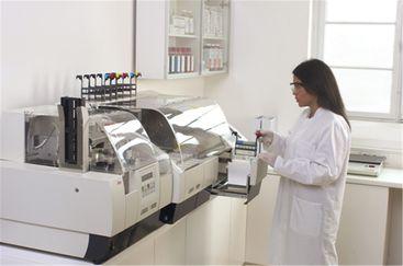 A rack of paraffin sections being loaded onto an automated stainer for H&E staining. This instrument will stain the sections. The adjacent automated glass coverslipper will apply glass coverslips to the surface of the sections to preserve them and provide optimal optical conditions for microscopy.